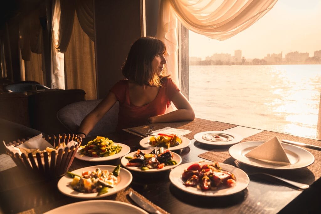 a young tourist having dinner on a boat on the nil 2022 03 09 22 07 27 utc